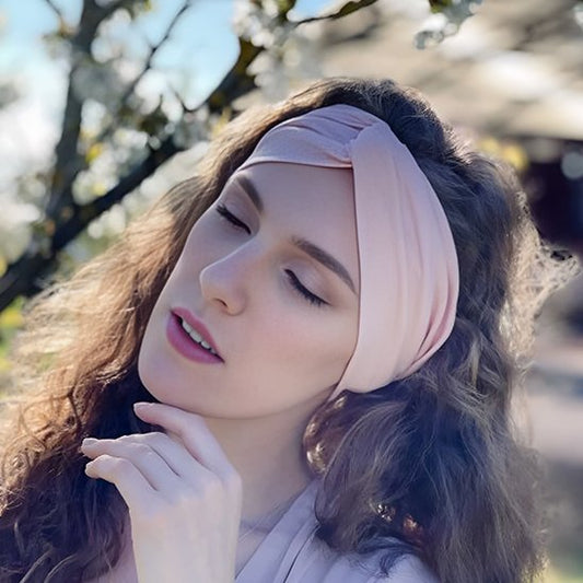 Bandeau cheveux Femme portant un bandeau cheveux rose croisé style bohème chic.