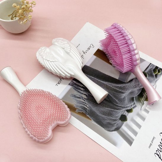Brosse à cheveux démêlante en forme d'ailes d'ange rose et blanche avec ses picots souples