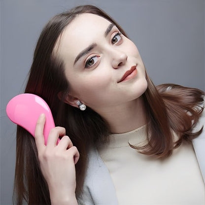 Brosse à cheveux Femme brune présentant le peigne de massage ergonomique rose pour le soin quotidien des cheveux
