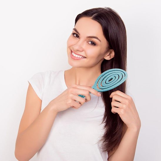 Brosse cheveux bouclés Femme heureuse utilisant une brosse magique démêlante sans douleur pour toute la famille.