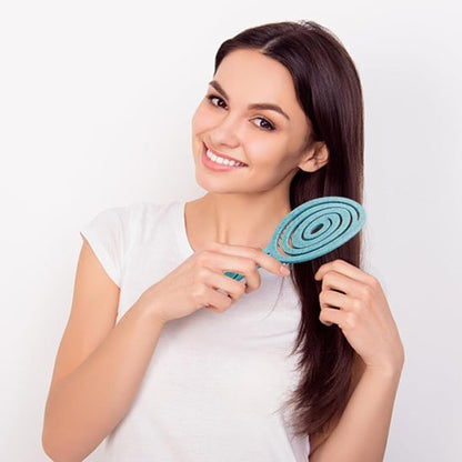 Brosse cheveux bouclés Femme heureuse utilisant une brosse magique démêlante sans douleur pour toute la famille.